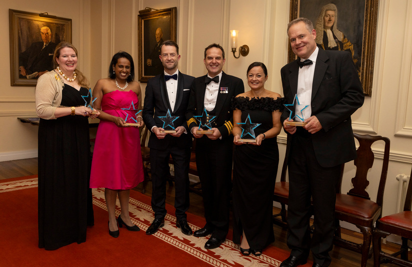 A photo of all the award winners standing and holding their awards
