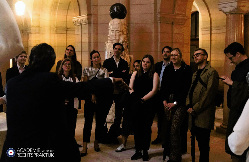 A photo of a group of people watching another person speak
