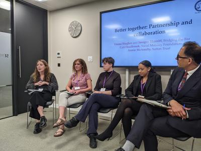 Five people sitting in a row in a panel session.
