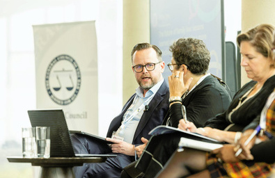 A photo of a panel of speakers on a stage in discussion