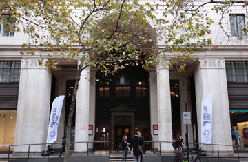 The façade of Bush House, Aldwych (geograph 4238525). There people talking and two of the Bar Council's Pupillage Fair standing banners out the front.