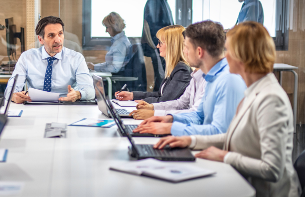 People sitting around a table in front of laptops