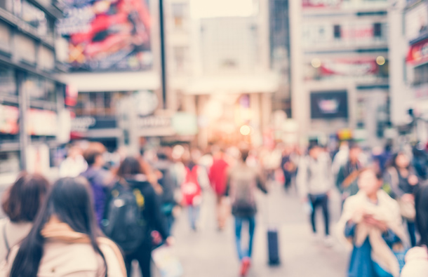 Blurred picture of people walking on a road.