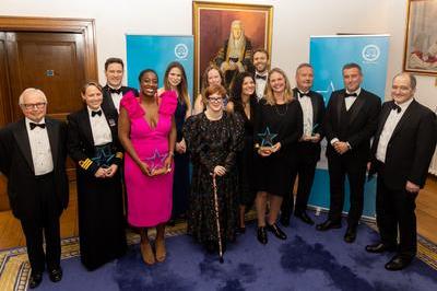 Employed Bar Awards winners holding their star shaped awards in front of blue banners.