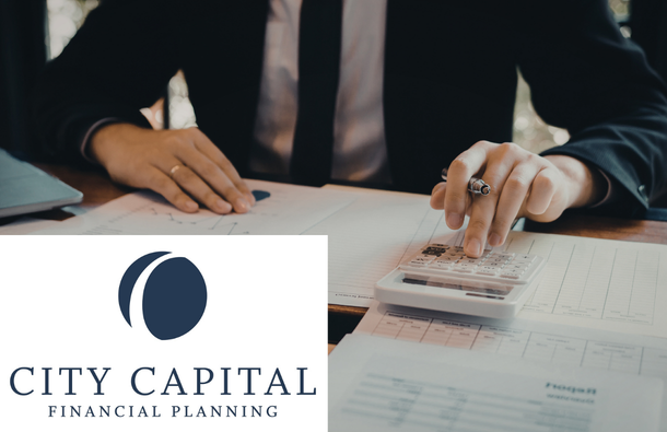 Business person at desk using a calculator.