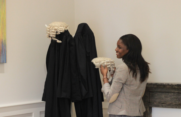 A photo of a person hanging their barrister wig on top of their gown