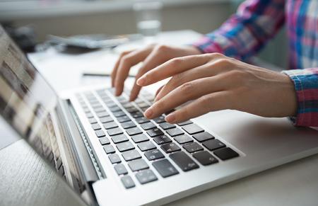 Hands typing on a laptop keyboard